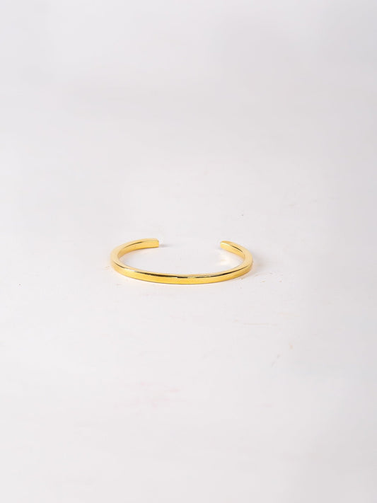 Gold bracelet on a light gray background