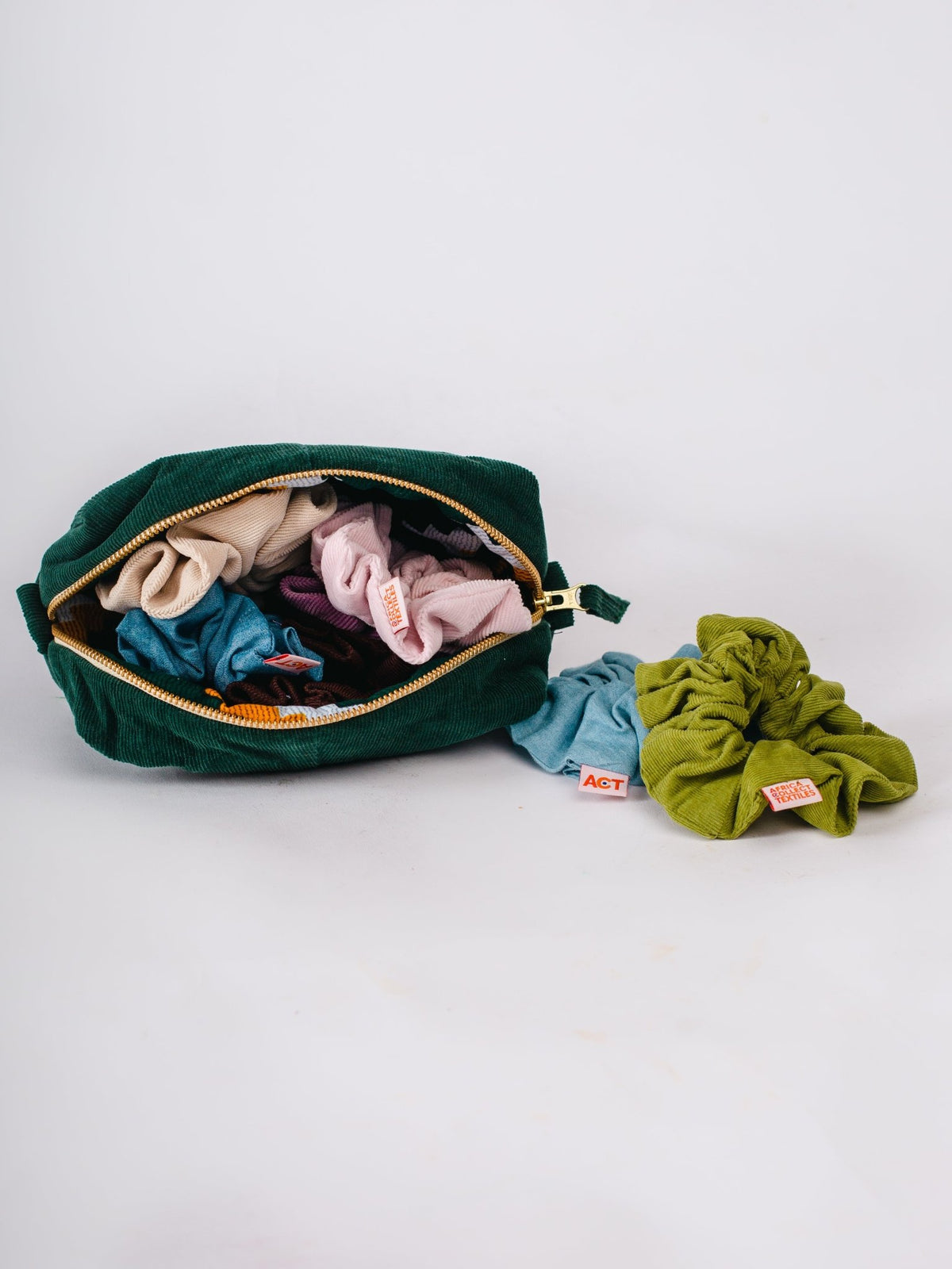 Green pouch with colorful scrunchies on a white background