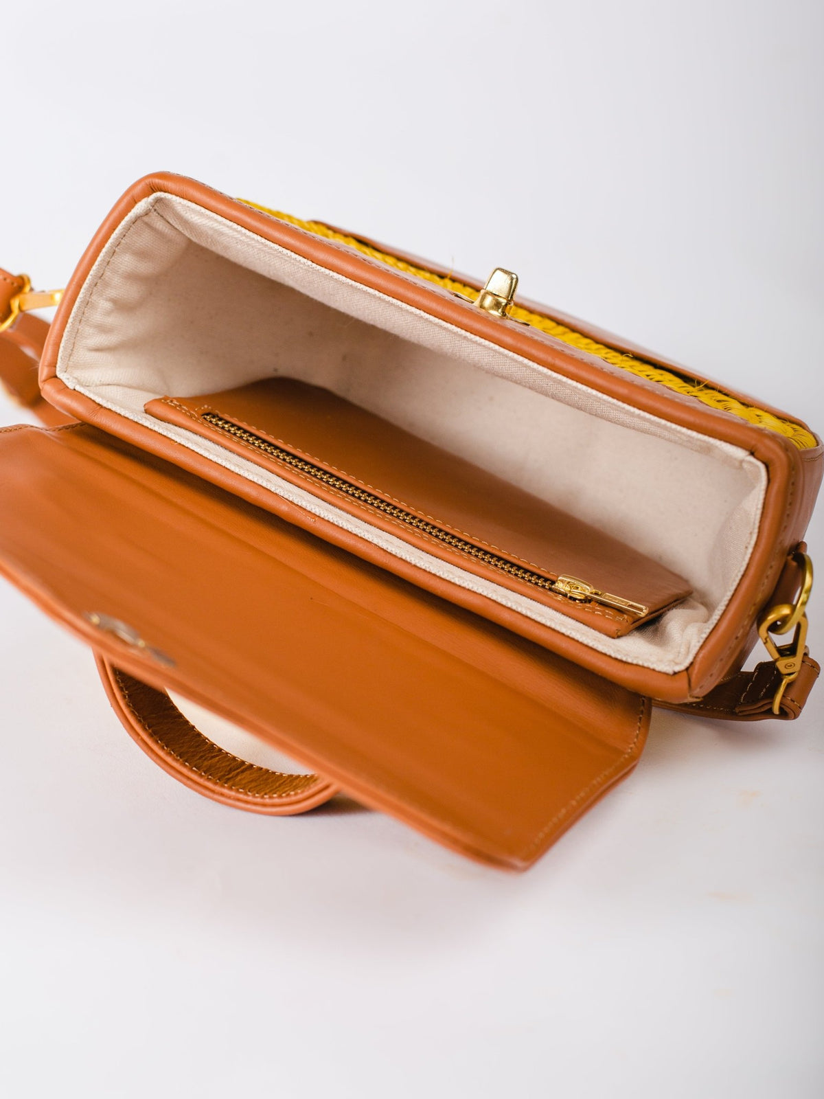 Brown leather handbag with open flap on a white background