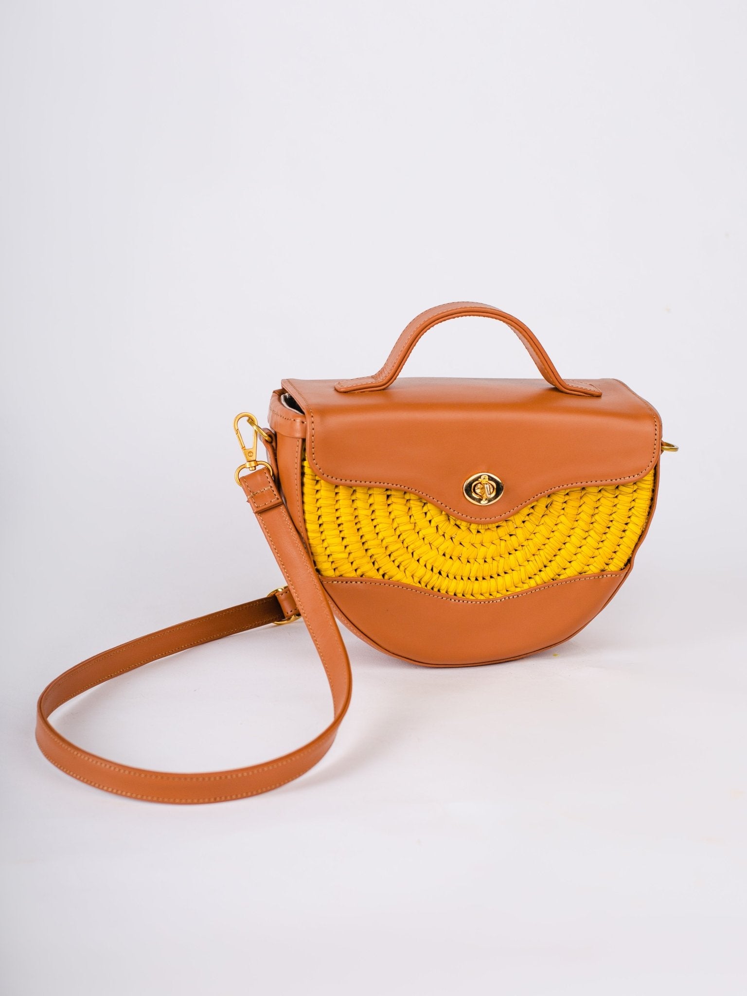 Brown handbag with yellow woven section on a white background