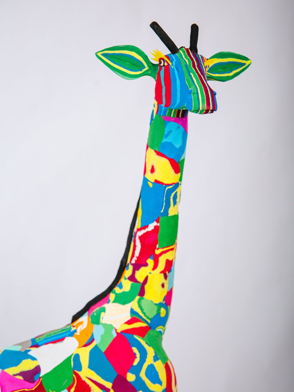 Colourful stuffed giraffe sculpture on a white background