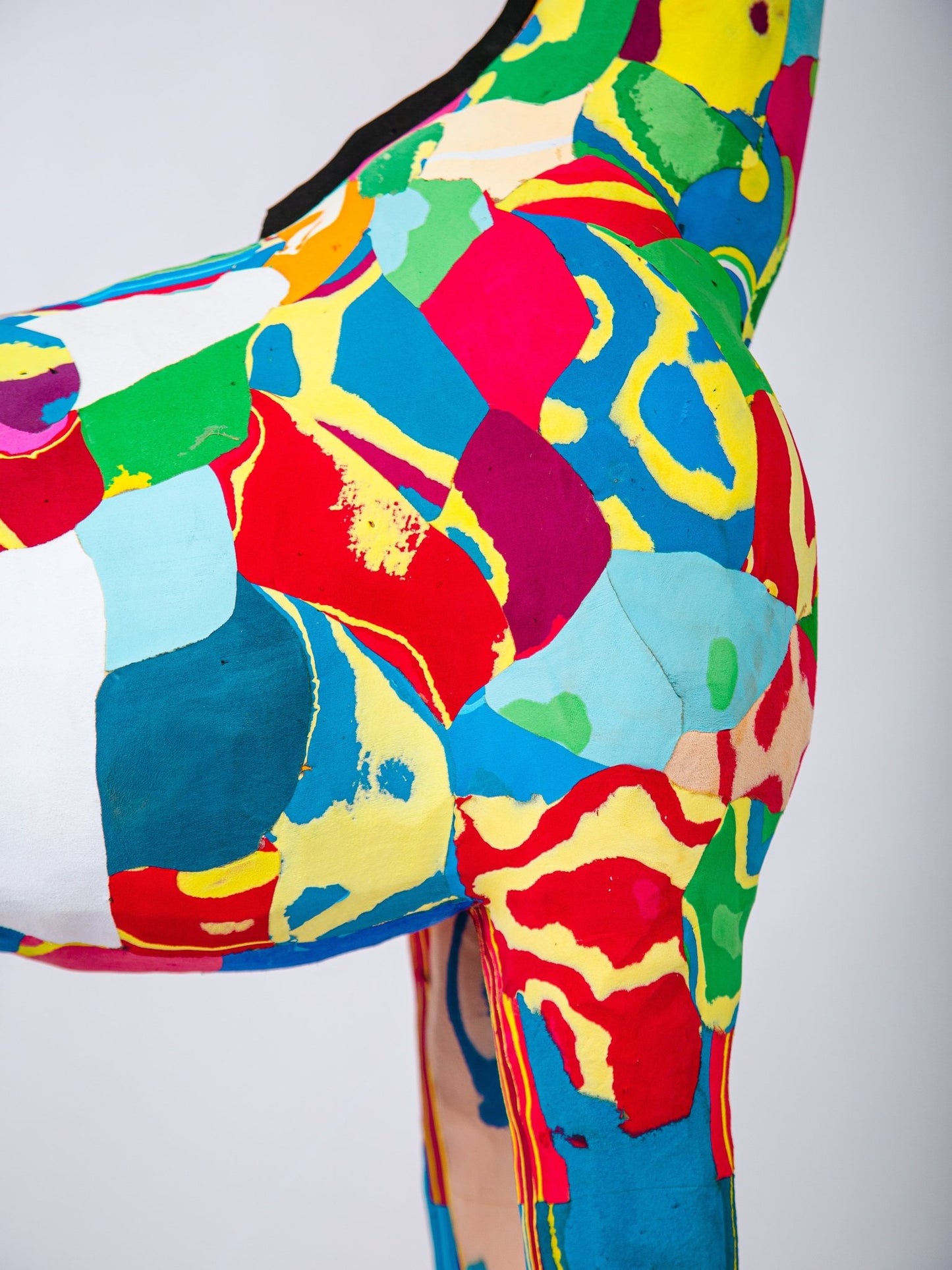 Colourful abstract patterned sculpture on a plain background