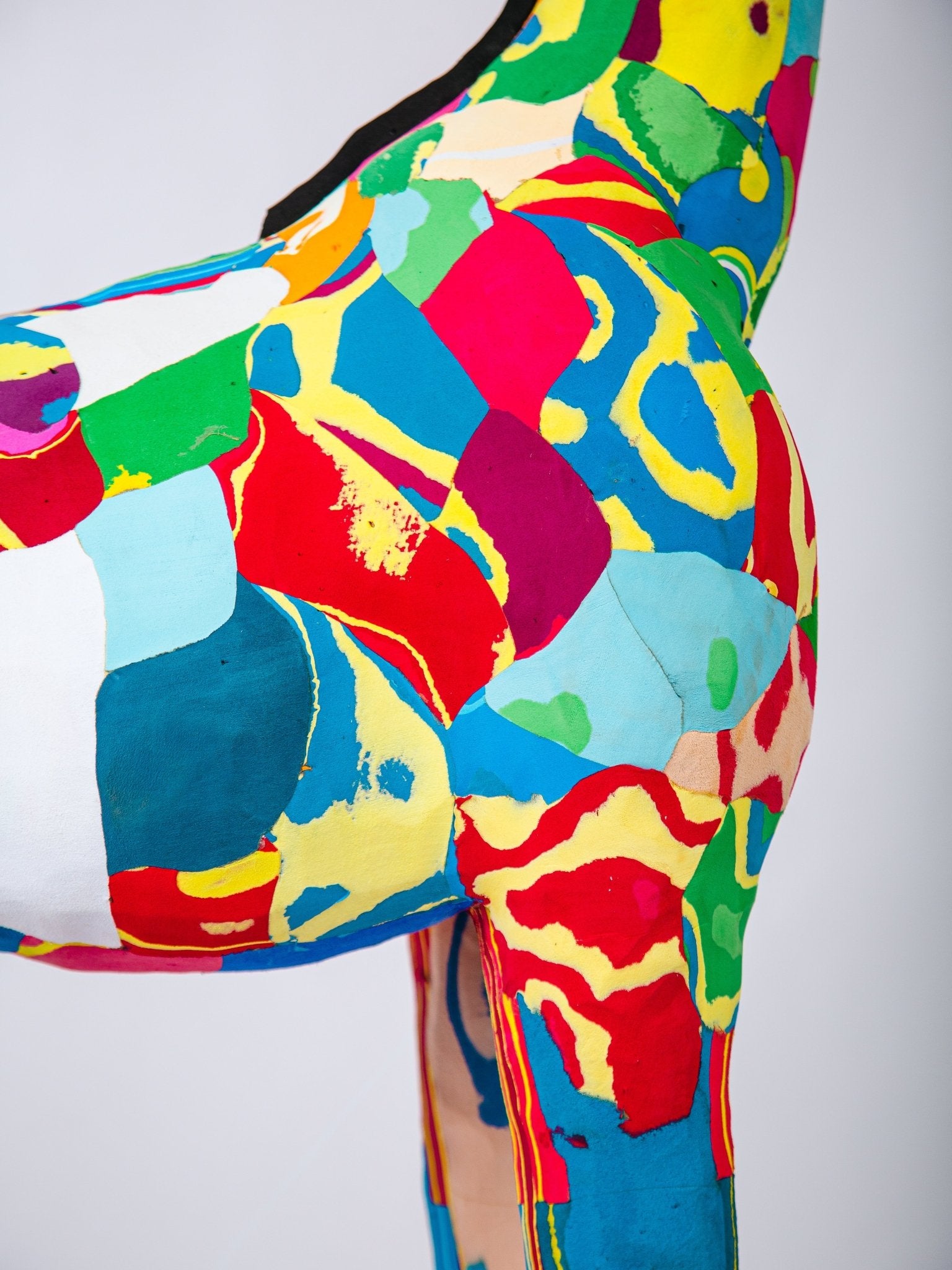 Colourful abstract patterned sculpture on a plain background