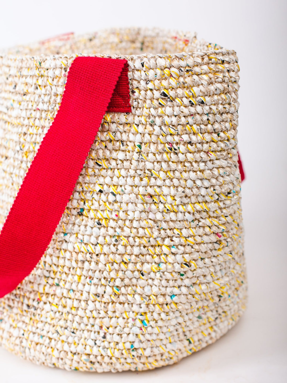 Woven basket with a red handle on a white background