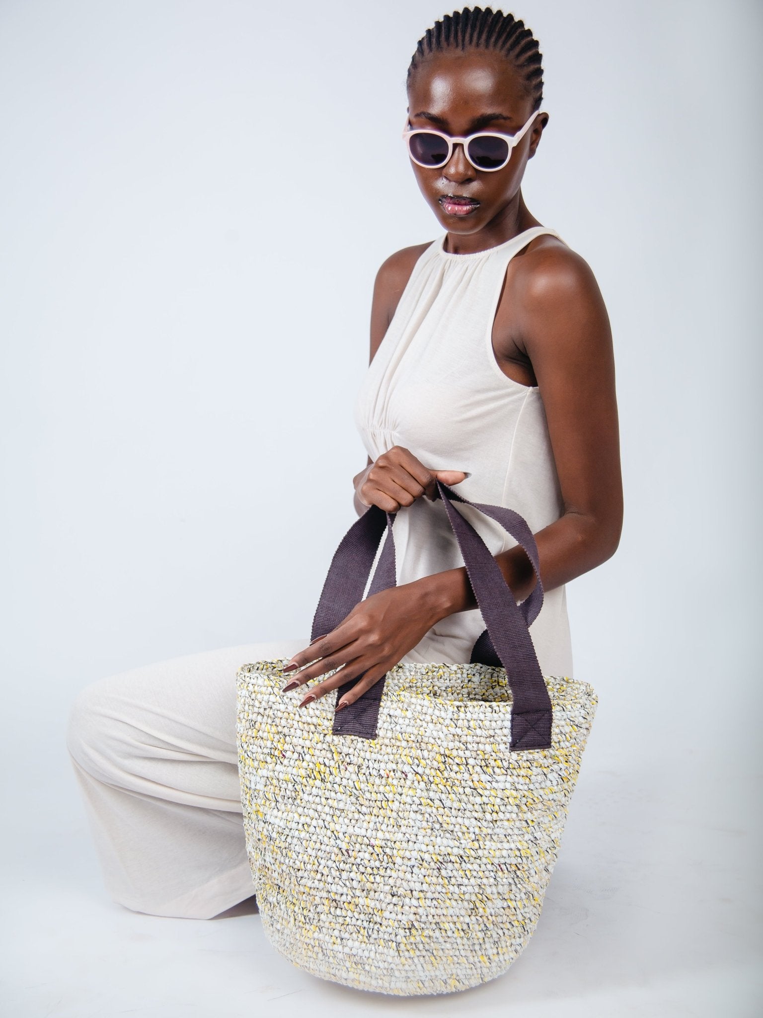 Woman holding a woven bag against a white background