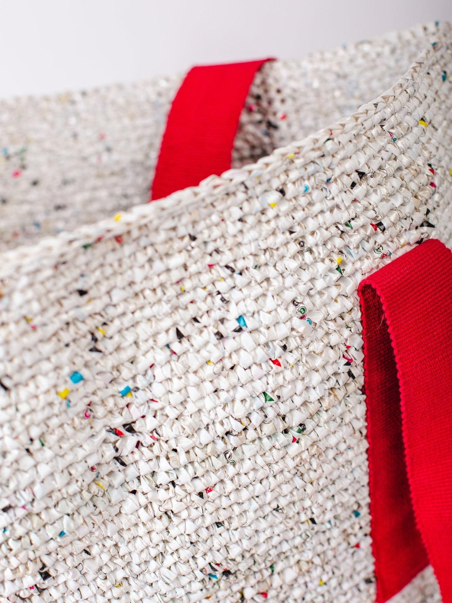 Textured fabric with colorful specks and red accents