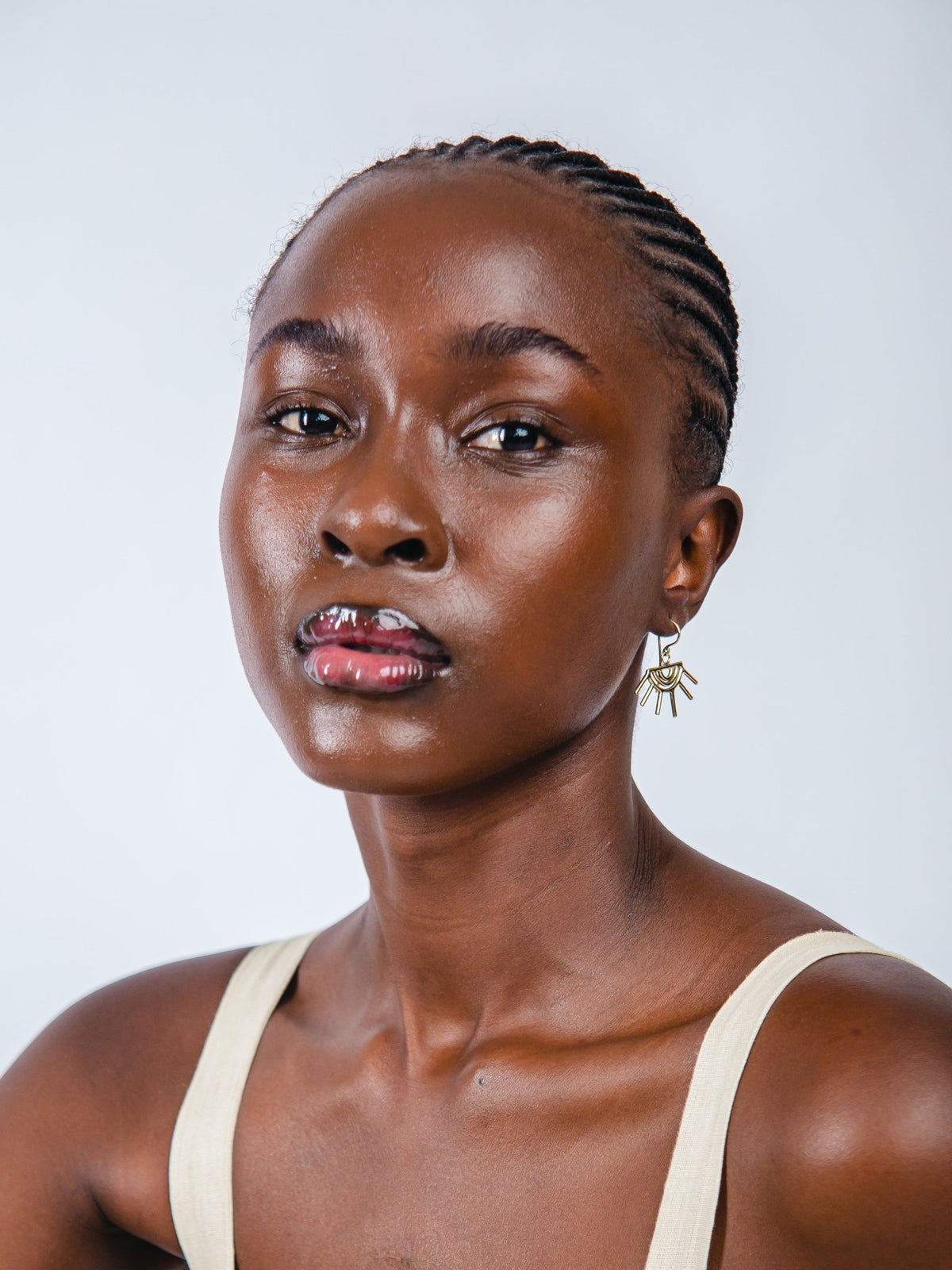 Woman wearing a beige tank top against a plain background
