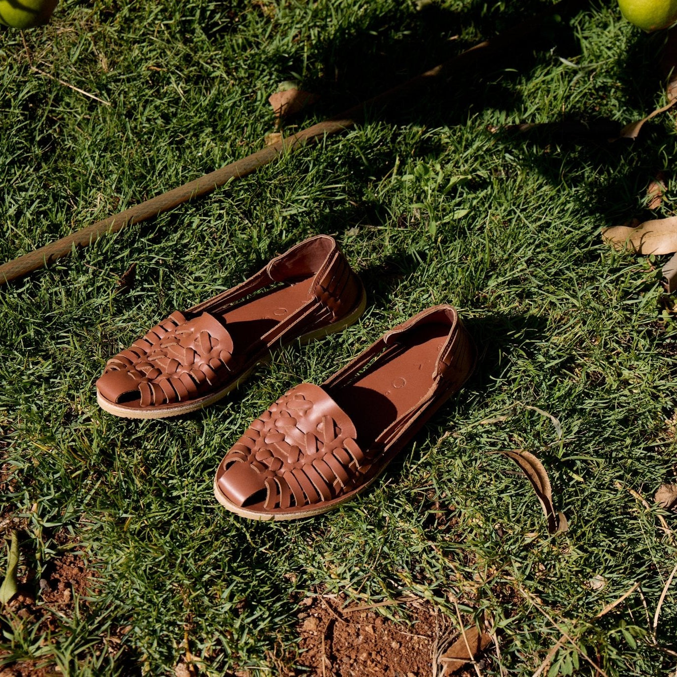 Pair of brown sandals on grass