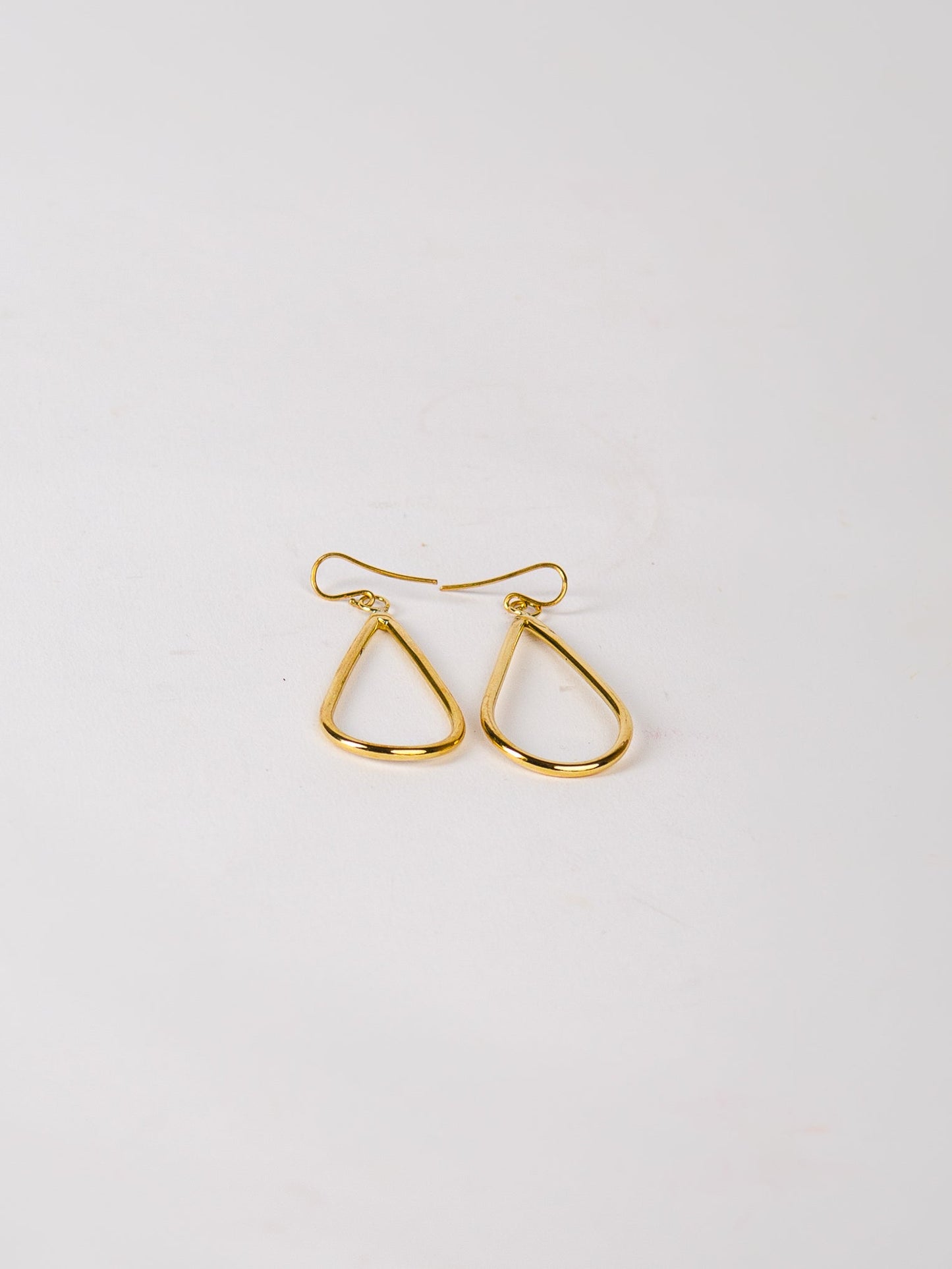Gold hoop earrings on a light gray background