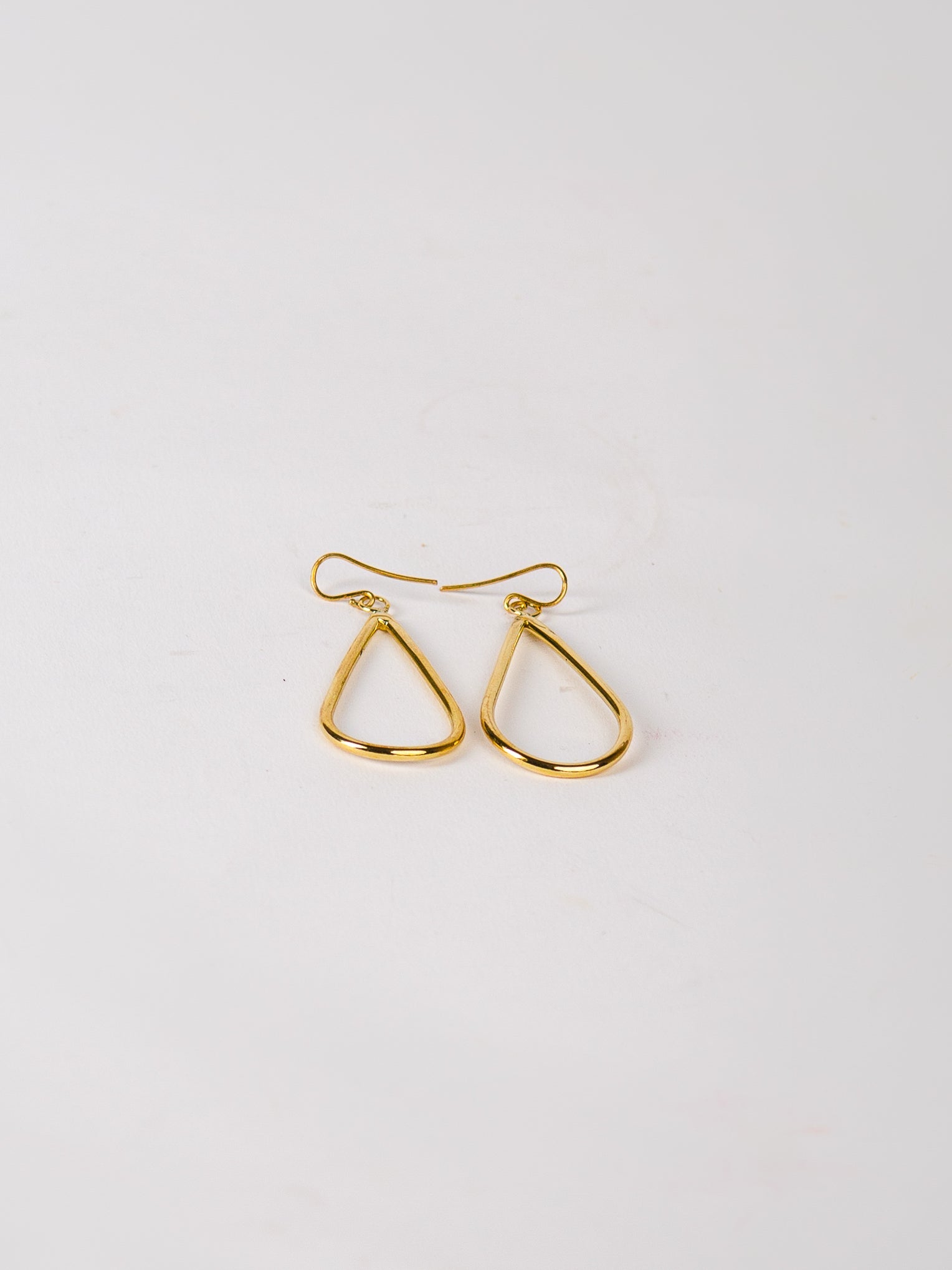 Gold hoop earrings on a light gray background