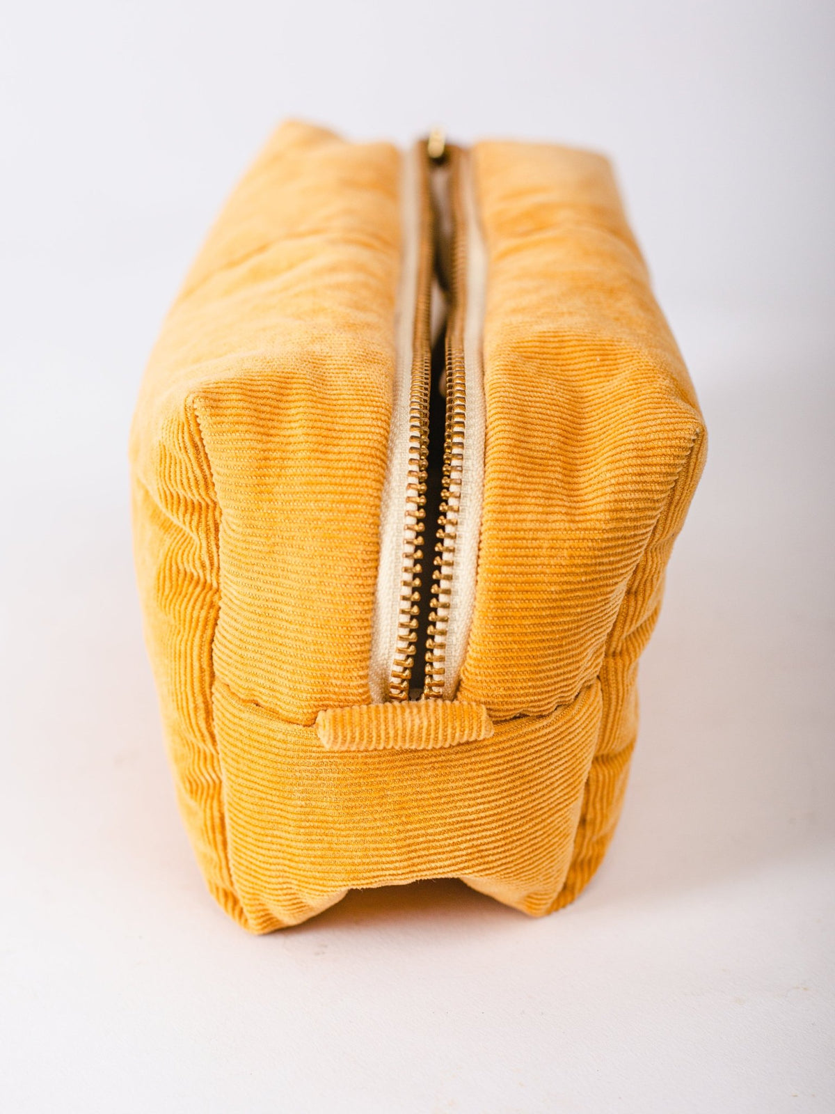 Yellow corduroy pouch with a zipper on a white background
