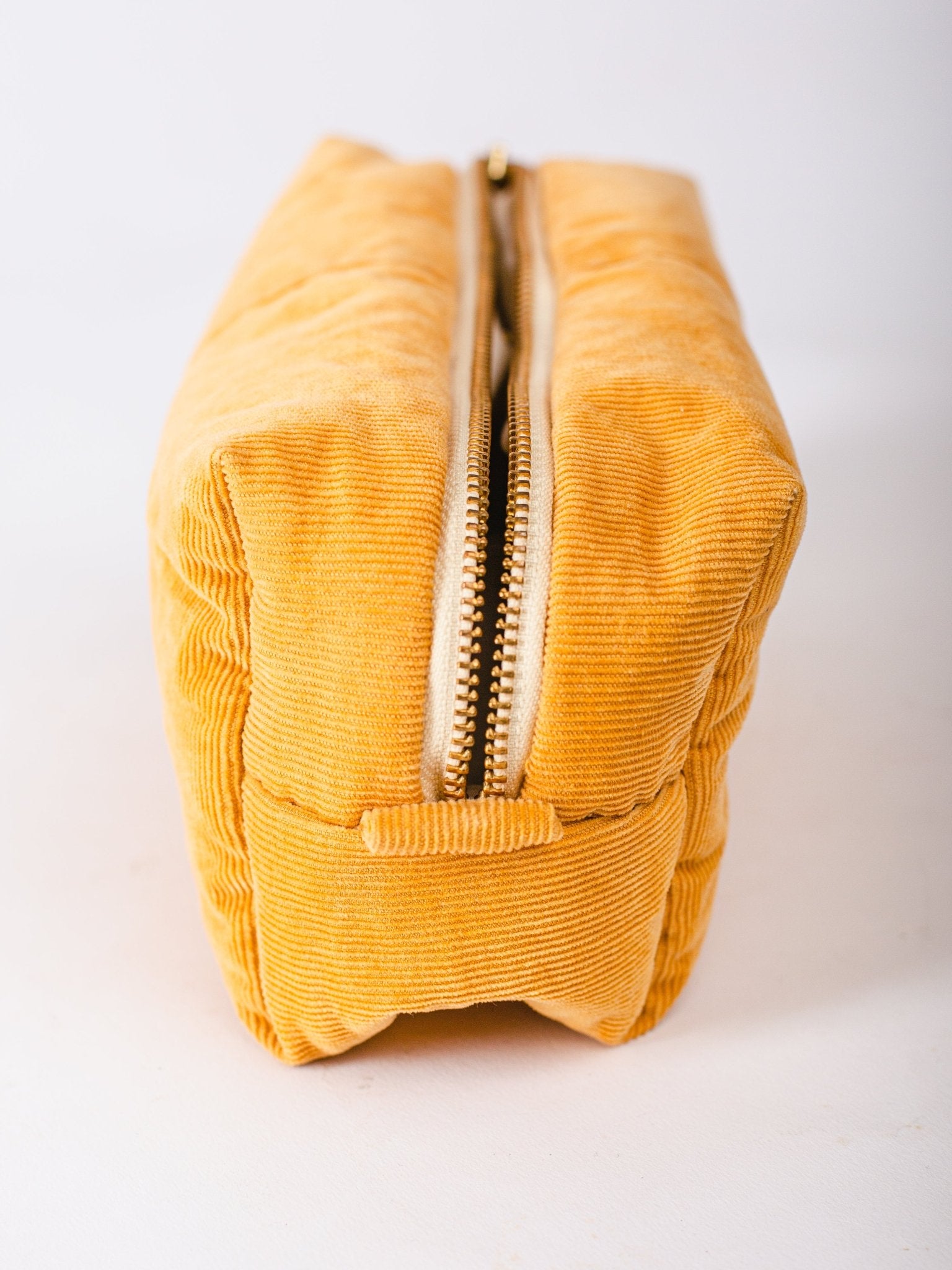 Yellow corduroy pouch with a zipper on a white background