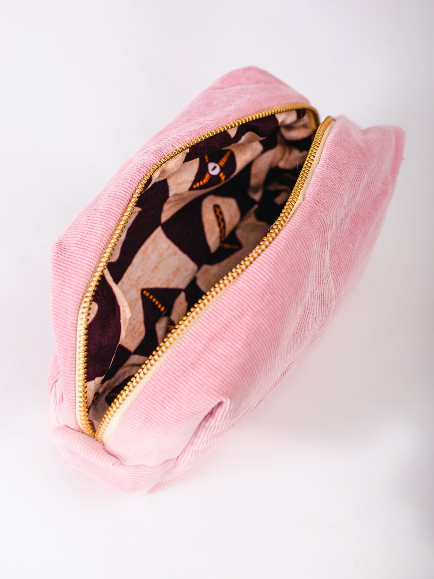 Pink pouch with a camouflage interior on a white background
