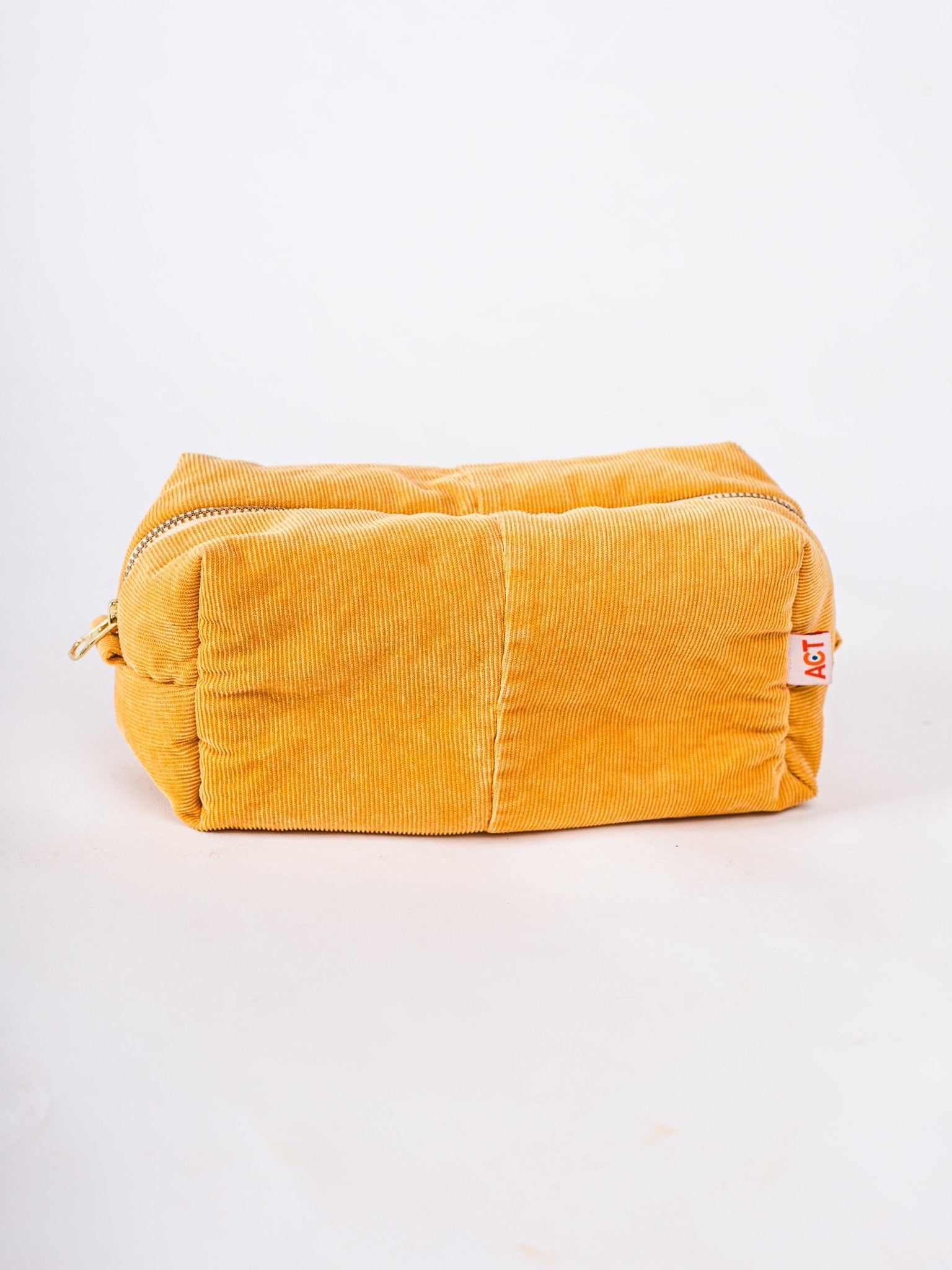 Yellow corduroy pouch with a brand label on a white background
