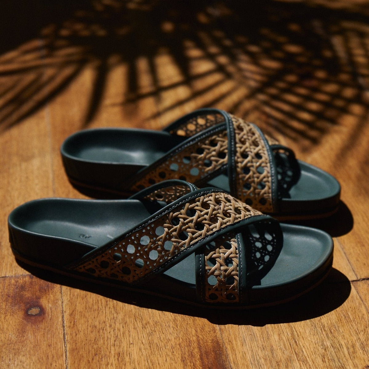 Pair of sandals with woven straps on a wooden floor