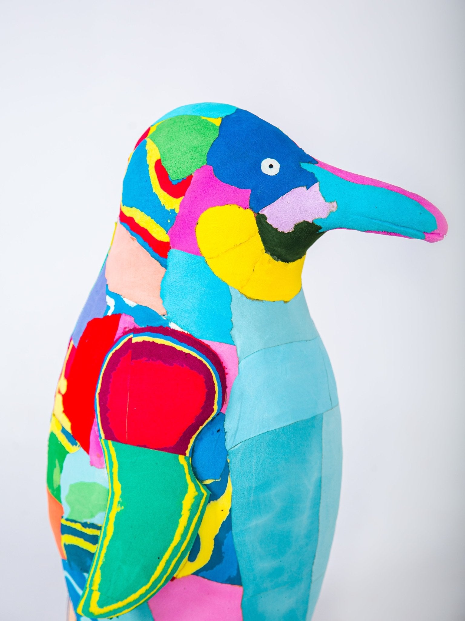 Colourful penguin plush sculpture on a white background