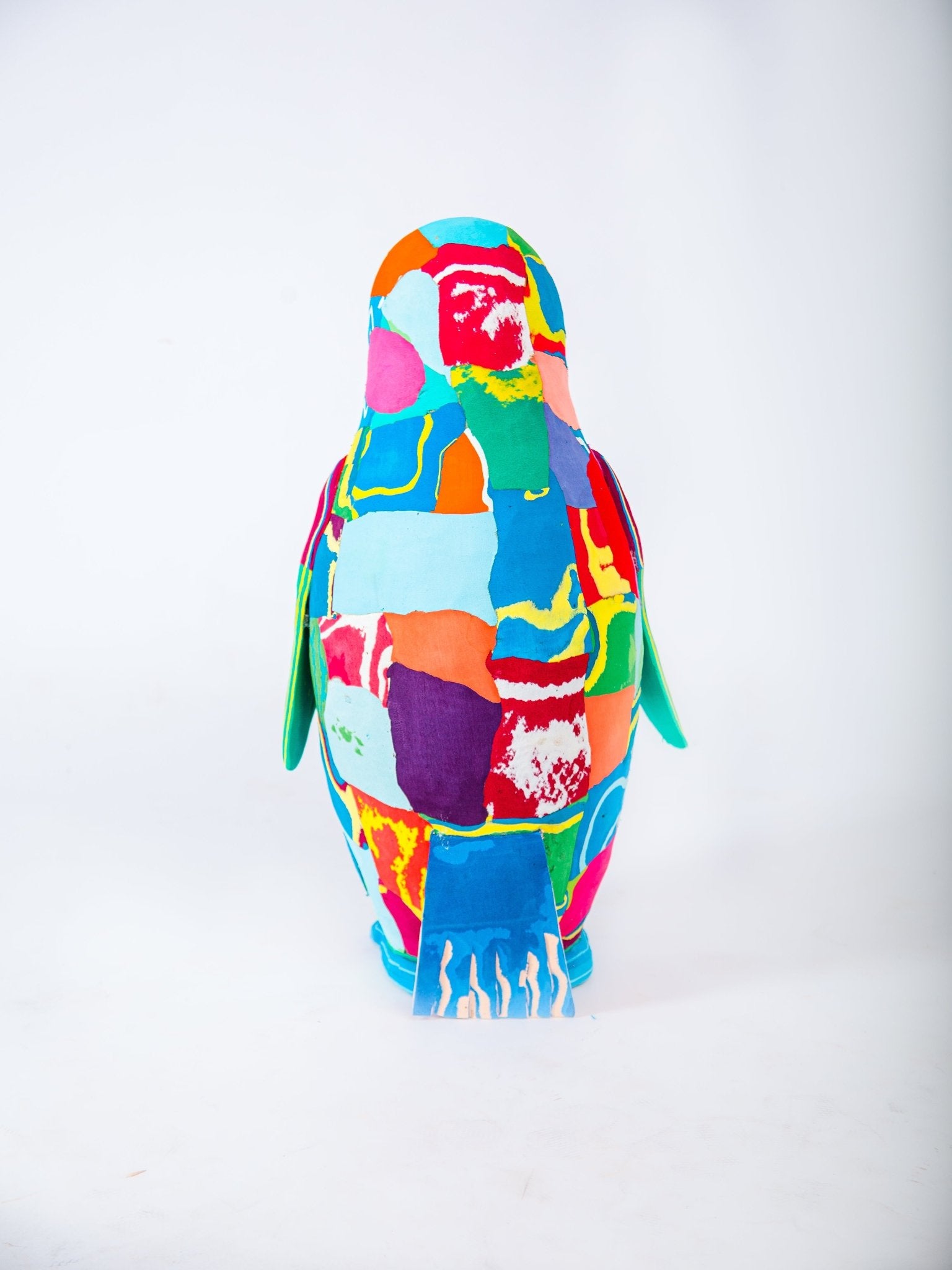 Colourful penguin plush sculpture on a white background