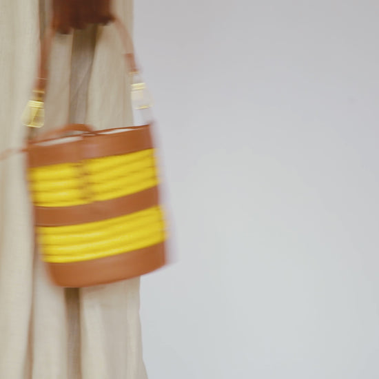 woman moving and carrying a bucket bag