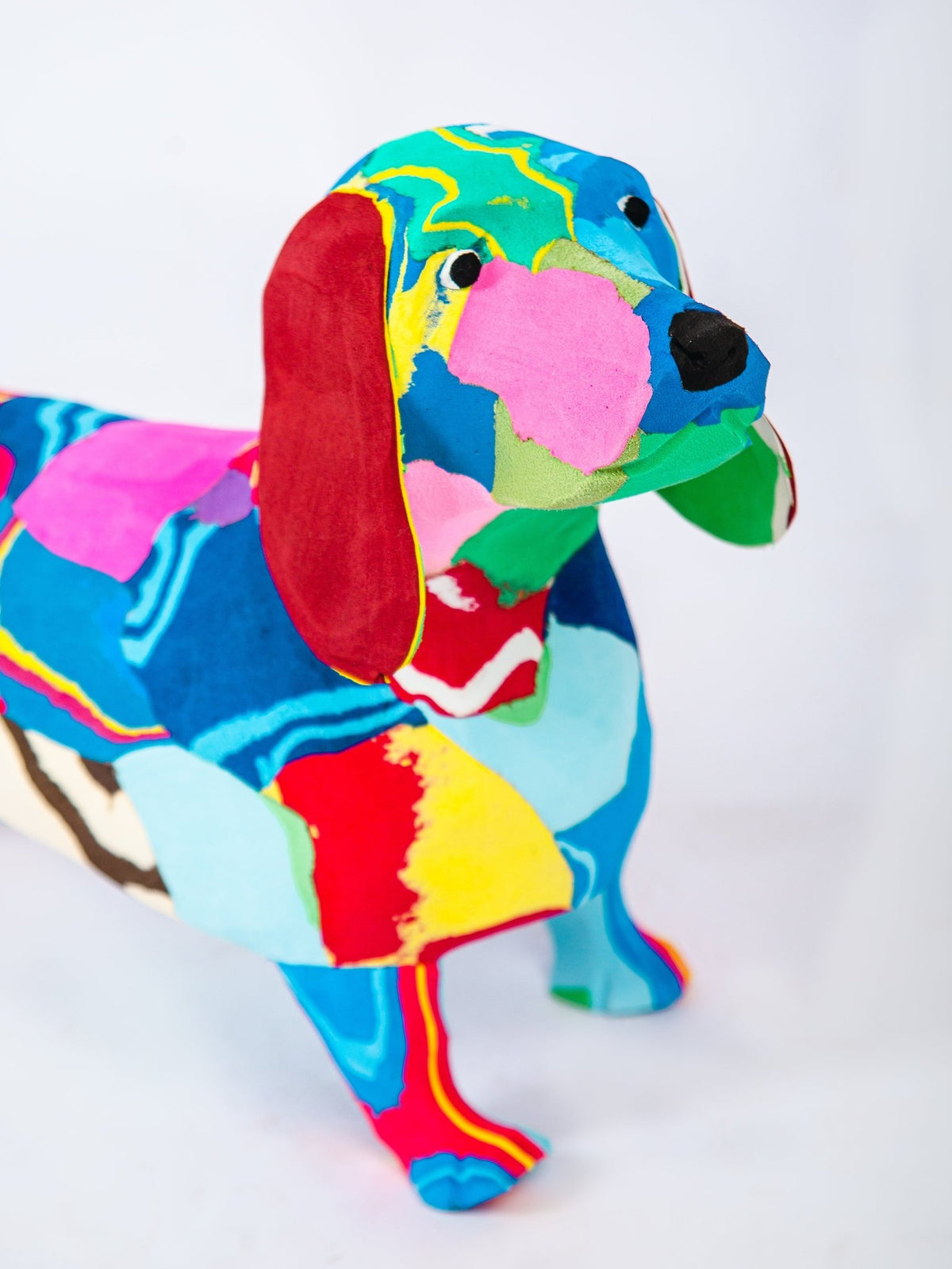 Colourful dog-shaped sculpture on a white background
