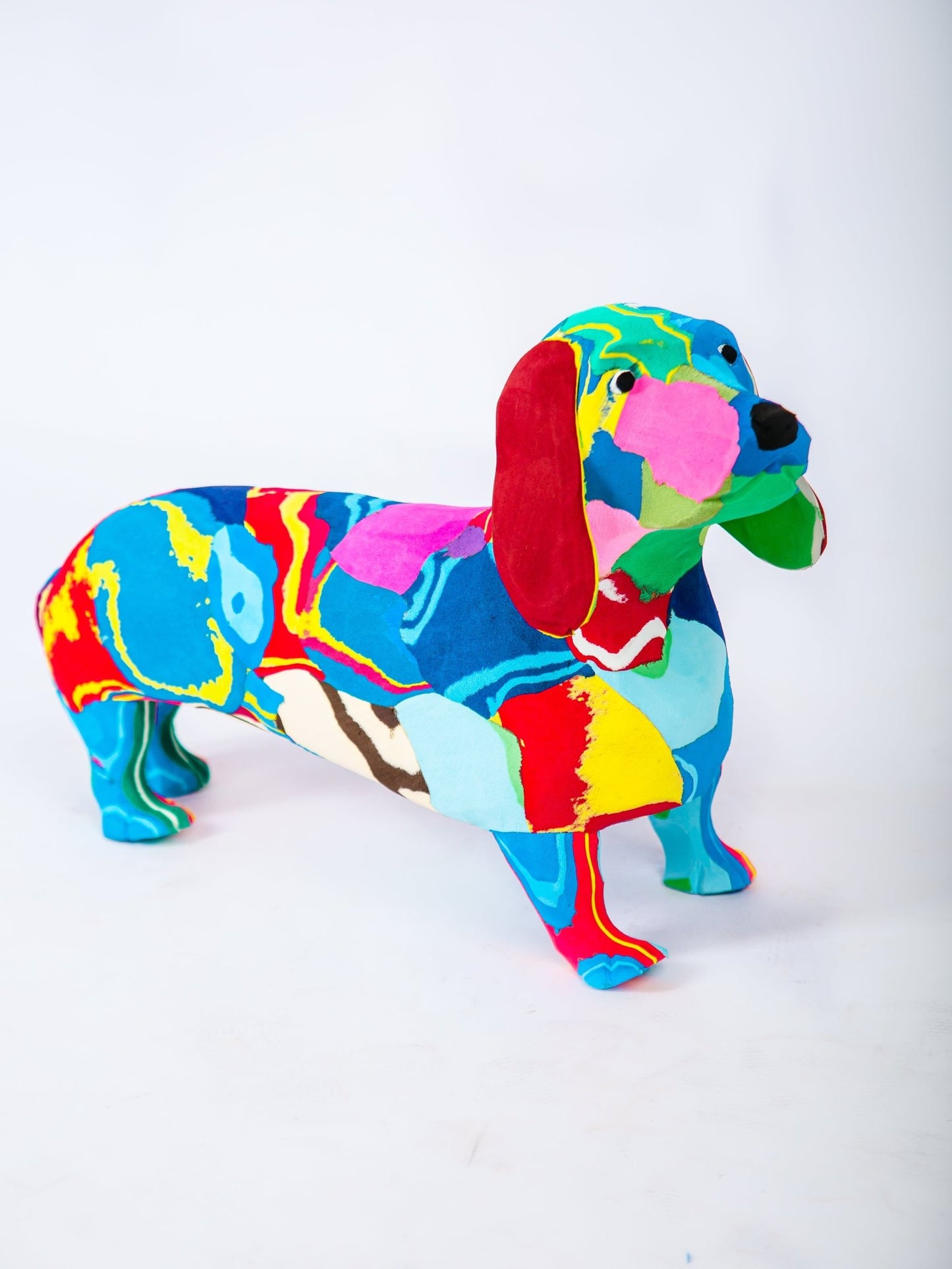 Colorful dachshund figurine on a white background