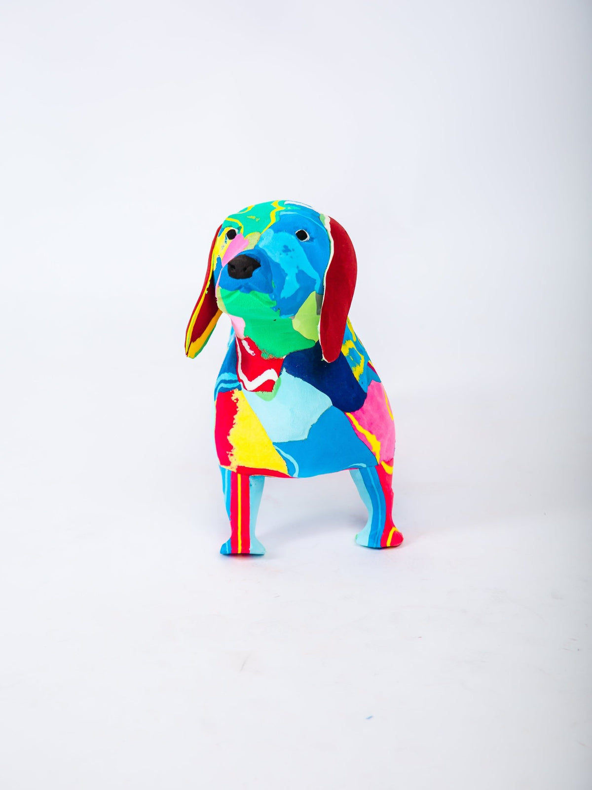 Colourful dog-shaped sculpture on a white background