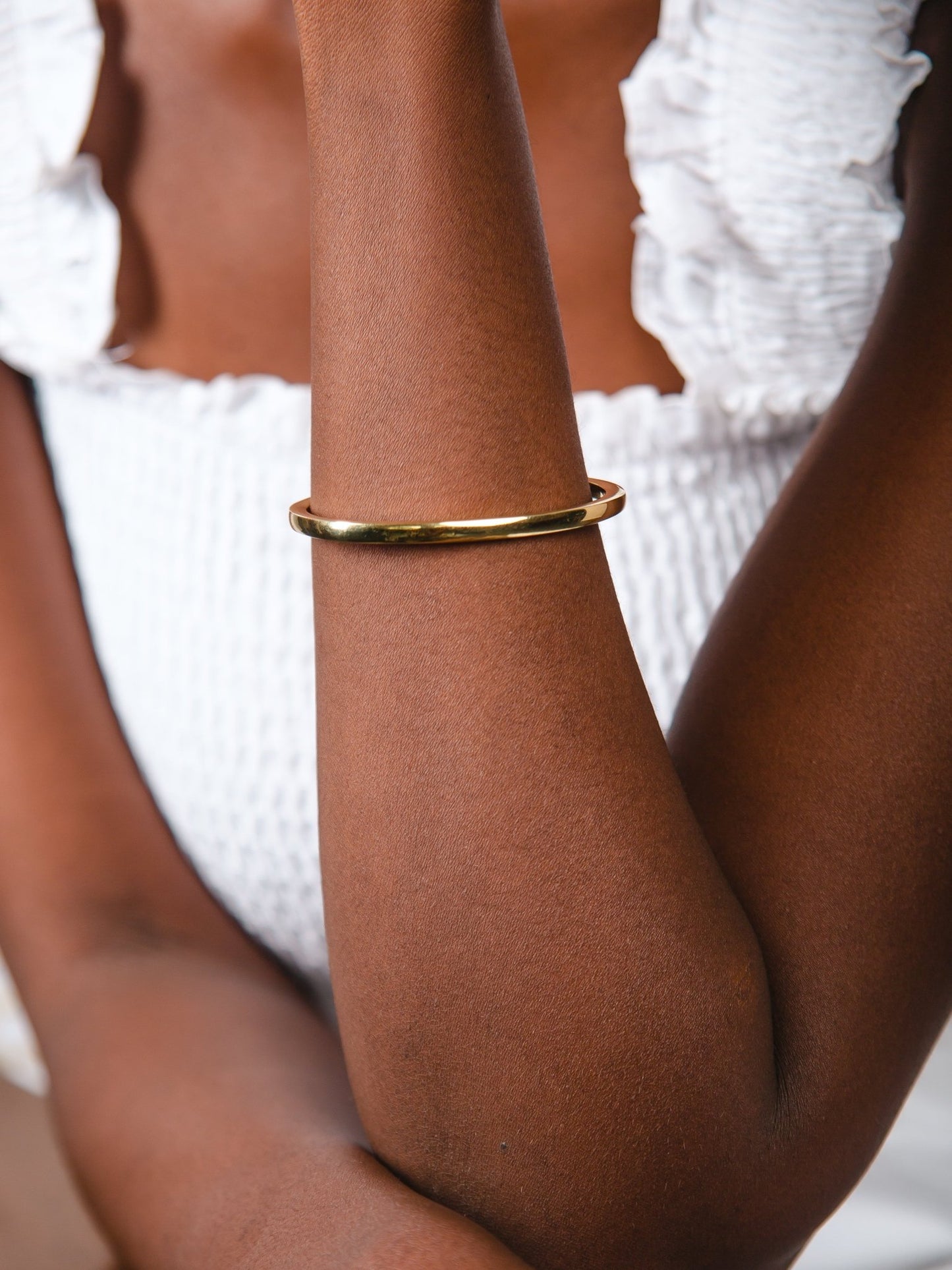 Gold bracelet on a person's wrist with a blurred background