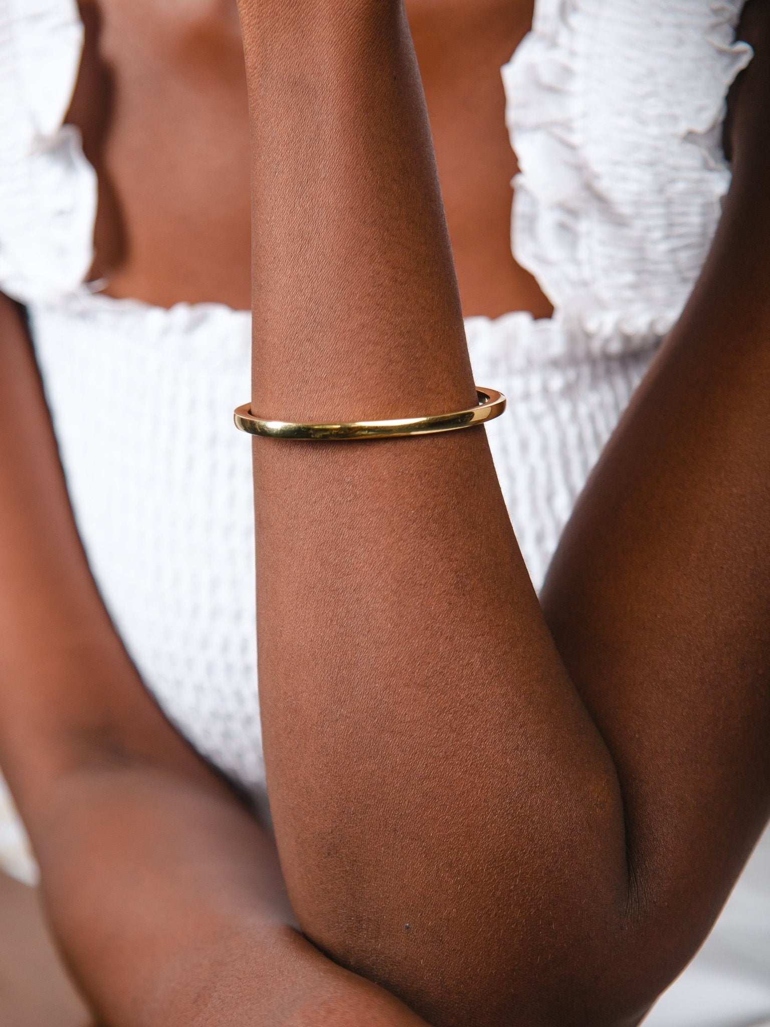 Gold bracelet on a person's wrist with a blurred background