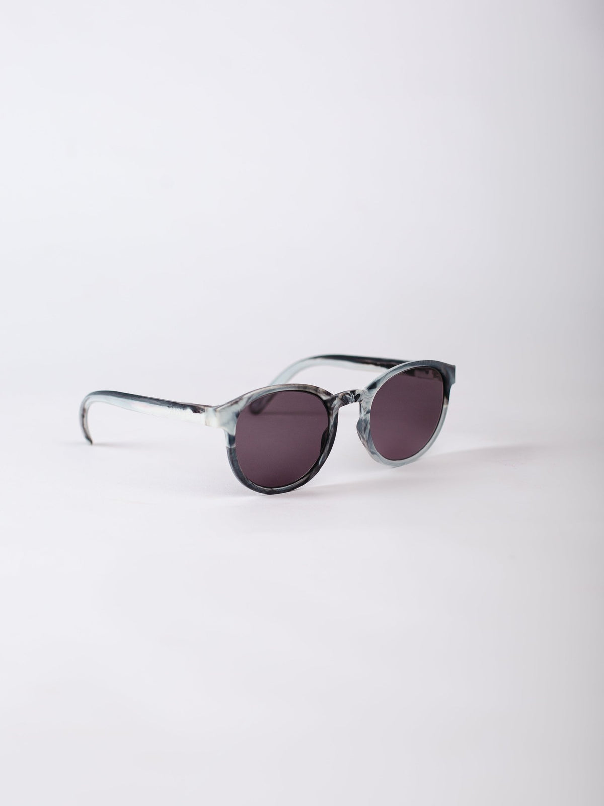 Sunglasses with a transparent frame and dark lenses on a white background