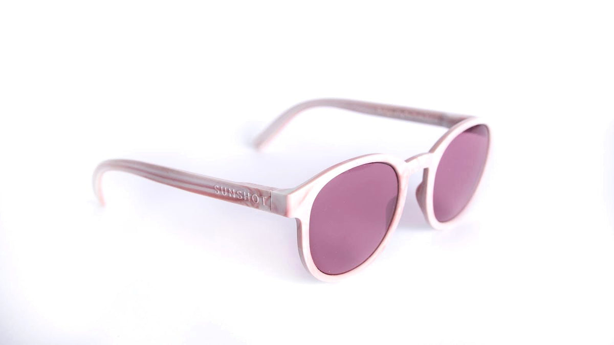 Sunglasses with pink lenses and rose gold frame on a white background