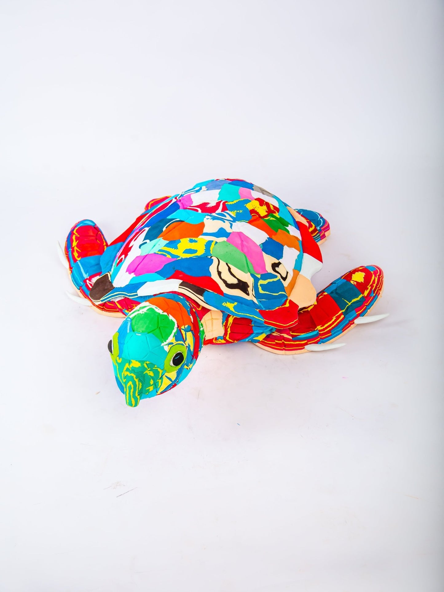 Colourful turtle-shaped sculpture on a white background