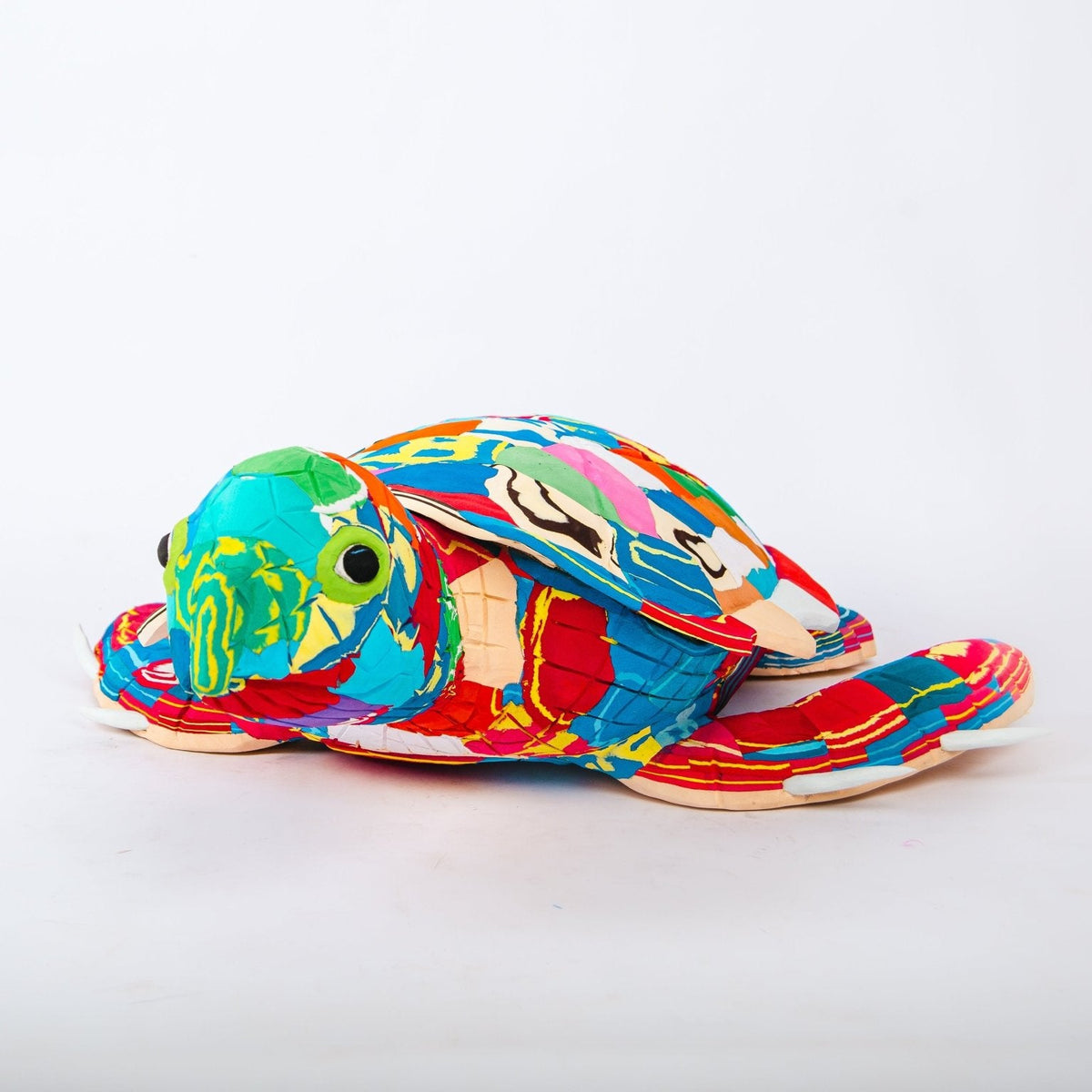 Coloruful turtle-shaped sculpture on a white background