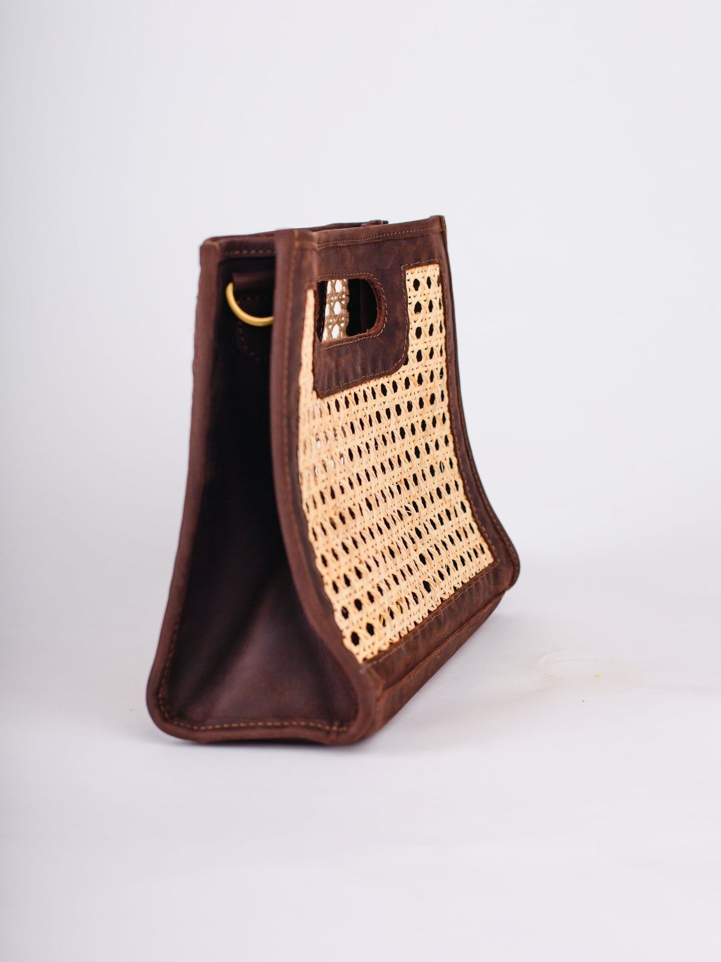 Brown leather handbag with woven pattern on a white background